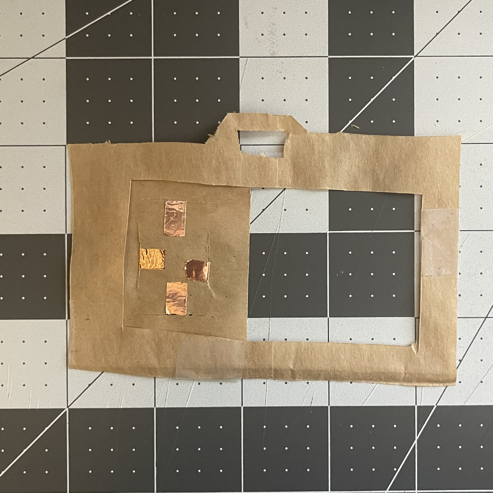 This was my first paper prototype regarding the camera sketch. It was just a flat piece of paper bag with some copper tape for some interactability.