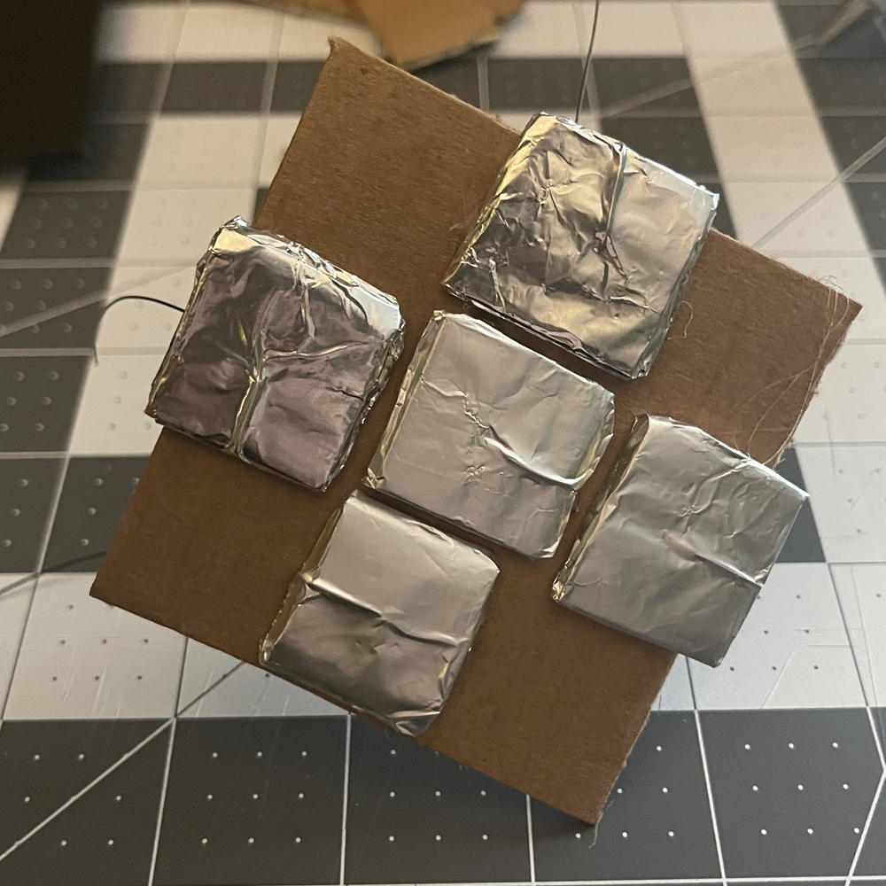 These are the buttons hooked up on the dancefloor. I cut out a piece of cardboard, hooked some wire around, then wrapped the button in tin foil so it would be easier for the user to press the buttons.